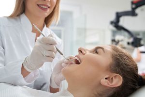 Dentist performing dental examination on patient, emphasizing preventive care and restorative options at Trail Ridge Dental.