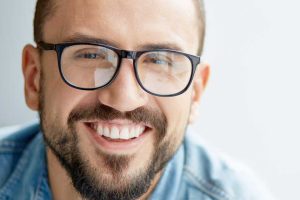 man with glasses showing off his new smile